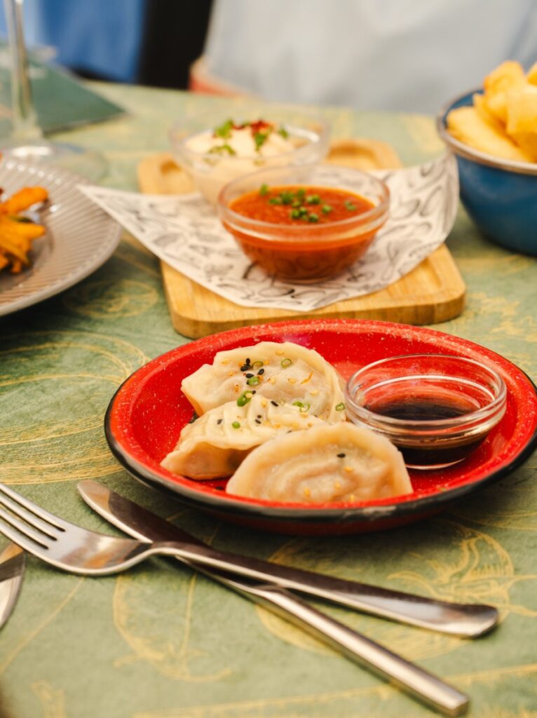 Gyozas con salsa de soja y otros platos para compartir en una mesa de Condendê