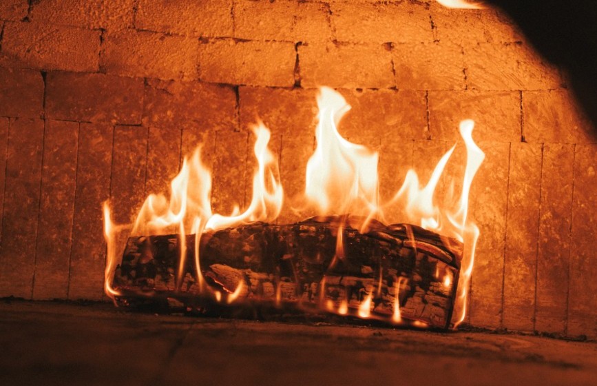 Fuego de leña ardiendo dentro del horno de Delantal Negro, en Sevilla